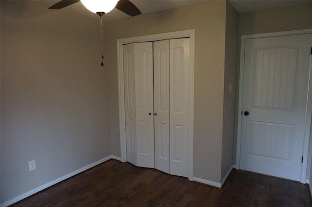 unfurnished bedroom with ceiling fan, a closet, and dark wood-type flooring