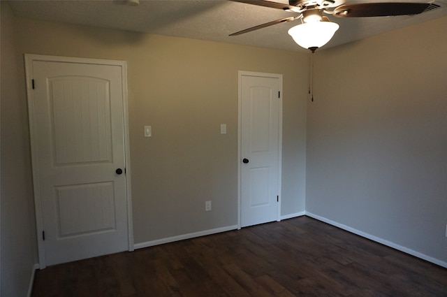 unfurnished room with ceiling fan and dark wood-type flooring