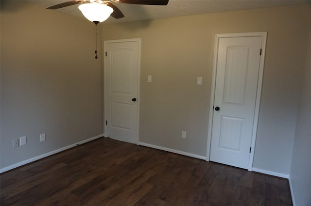 empty room with dark hardwood / wood-style floors and ceiling fan