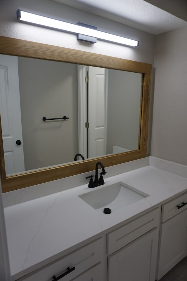 bathroom with a textured ceiling and vanity