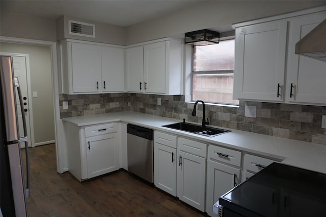 kitchen featuring white cabinetry, sink, dark hardwood / wood-style floors, backsplash, and appliances with stainless steel finishes