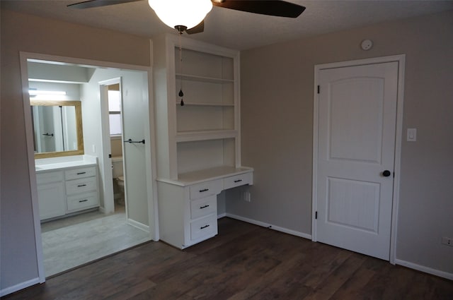 interior space featuring ceiling fan, dark hardwood / wood-style flooring, and built in desk