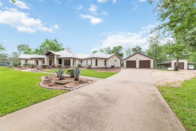 single story home featuring a garage, an outbuilding, and a front yard