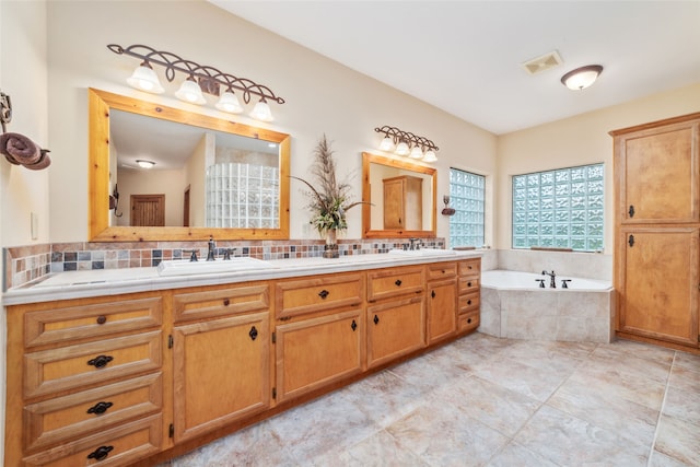 bathroom with vanity, tile patterned flooring, and a relaxing tiled tub