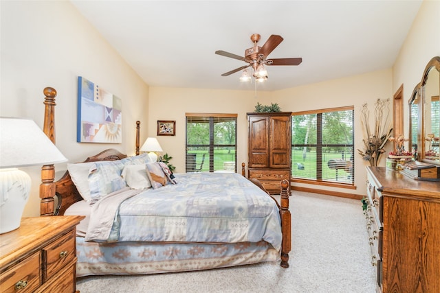 carpeted bedroom with multiple windows and ceiling fan