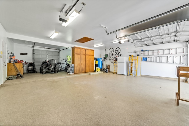 garage featuring white refrigerator and a garage door opener