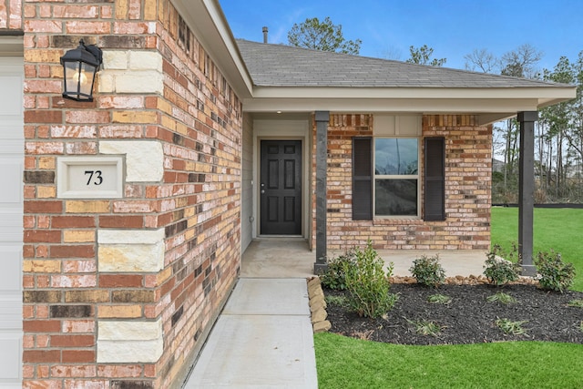 view of exterior entry featuring a porch and a lawn