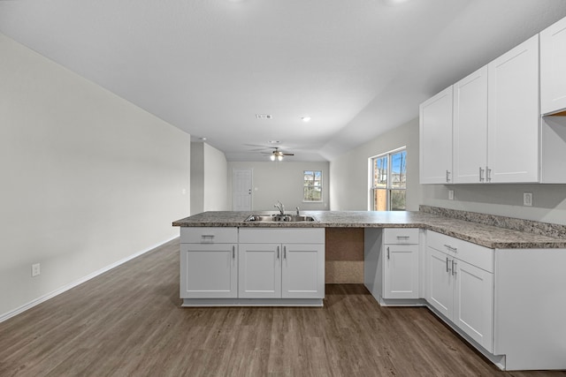 kitchen with kitchen peninsula, white cabinets, and sink