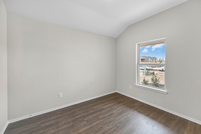 spare room with dark hardwood / wood-style flooring and vaulted ceiling