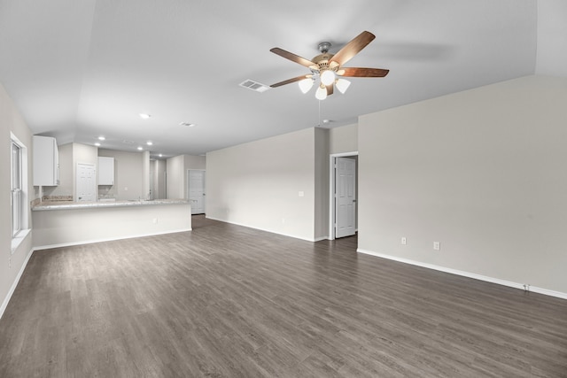 unfurnished living room featuring ceiling fan and dark wood-type flooring