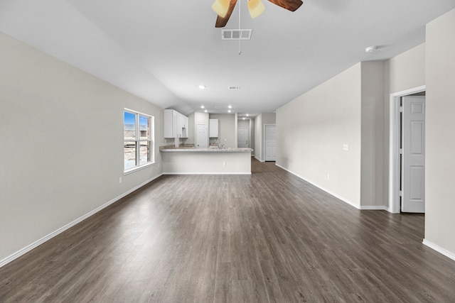 unfurnished living room featuring ceiling fan and dark wood-type flooring