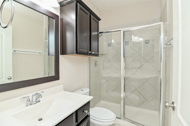 bathroom with vanity, toilet, and a shower with shower door