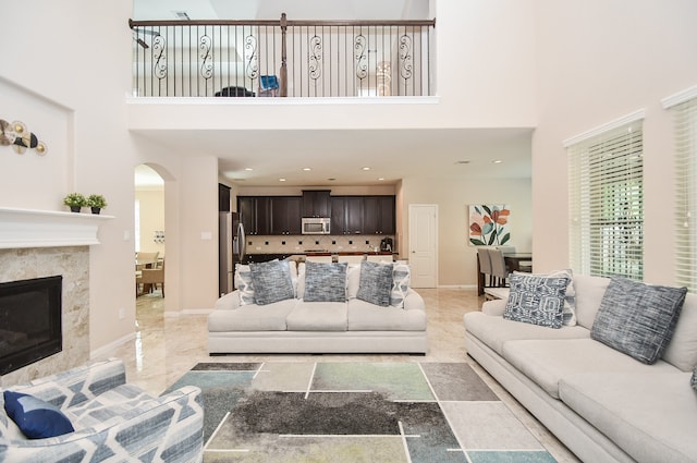 living room featuring a towering ceiling and a premium fireplace