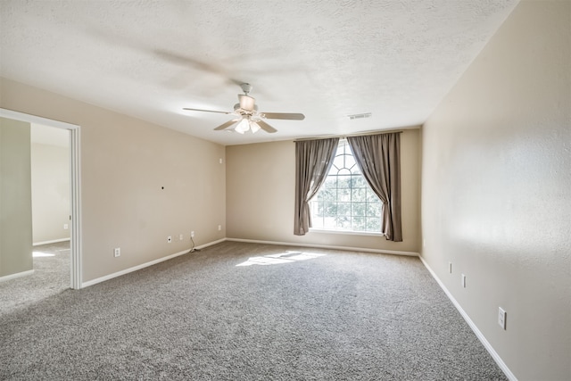 carpeted spare room featuring ceiling fan and a textured ceiling