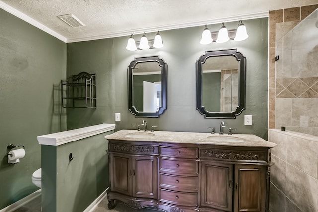 bathroom with crown molding, vanity, a textured ceiling, and toilet