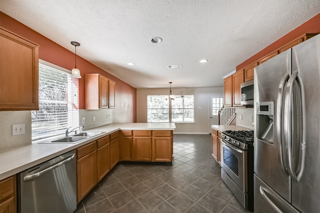 kitchen featuring a wealth of natural light, kitchen peninsula, hanging light fixtures, and appliances with stainless steel finishes