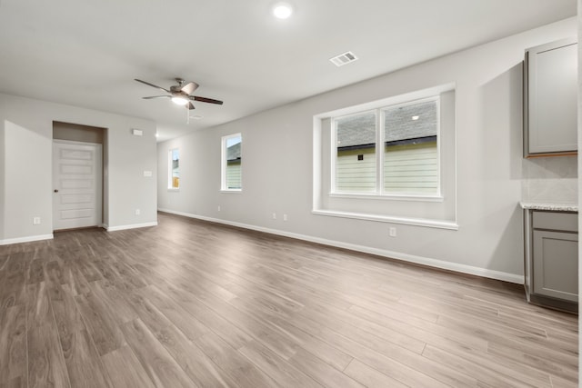 unfurnished living room with ceiling fan and light hardwood / wood-style flooring