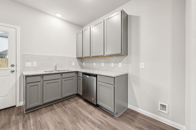 kitchen featuring light hardwood / wood-style flooring, stainless steel dishwasher, and gray cabinetry