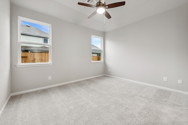 carpeted spare room with ceiling fan and a healthy amount of sunlight