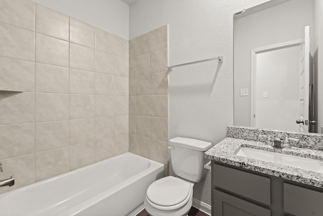 full bathroom with vanity, tiled shower / bath, and toilet