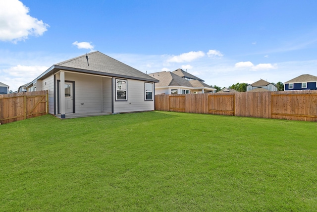 rear view of property with a yard