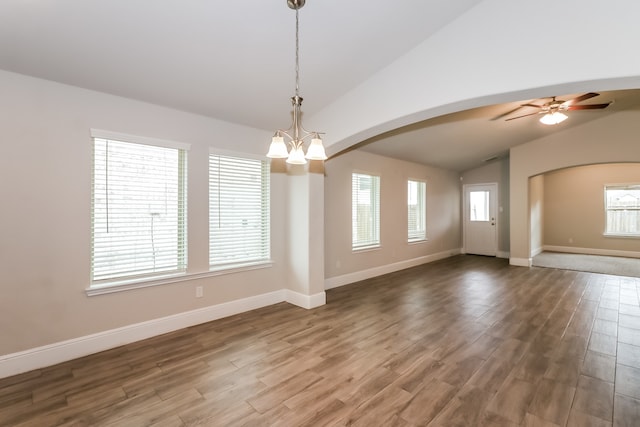 interior space featuring ceiling fan with notable chandelier, wood-type flooring, and vaulted ceiling