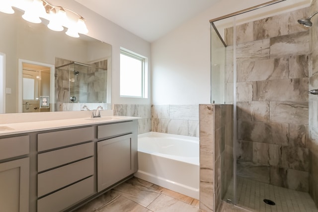 bathroom featuring shower with separate bathtub, vanity, and vaulted ceiling