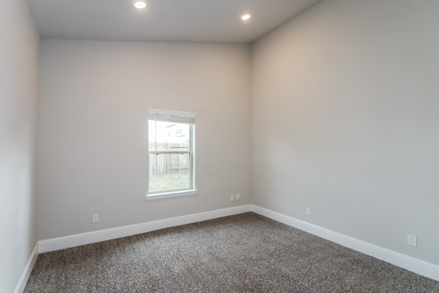 carpeted empty room featuring lofted ceiling