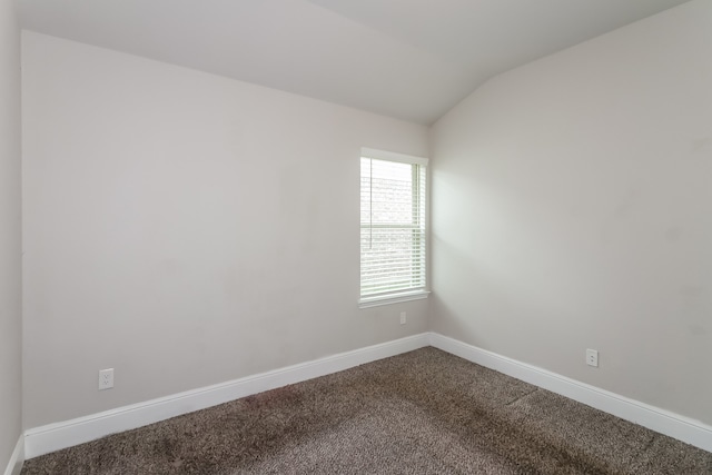 carpeted empty room with lofted ceiling