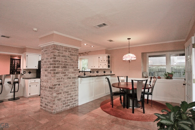 dining room with crown molding, sink, and a textured ceiling