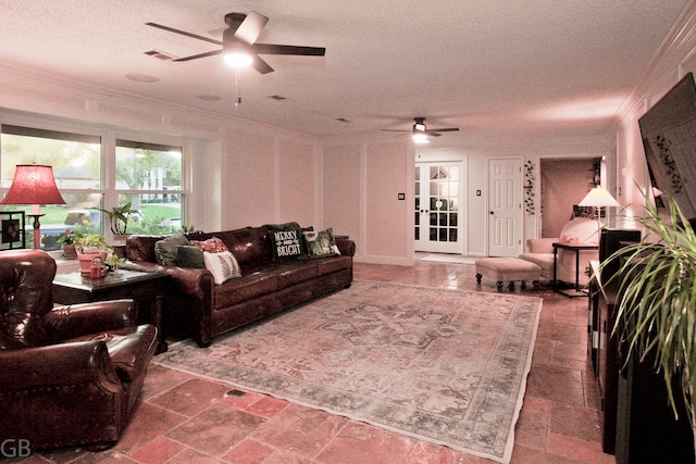 living room with a textured ceiling, ceiling fan, and ornamental molding