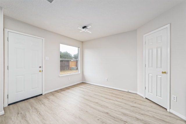 foyer with light wood finished floors and baseboards