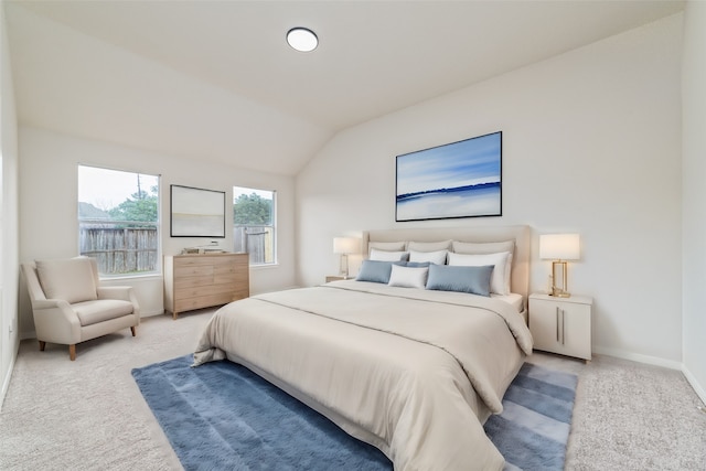 bedroom with carpet floors, lofted ceiling, and baseboards