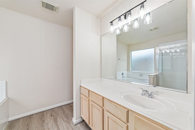 full bathroom with visible vents, a shower stall, a bath, and wood finished floors