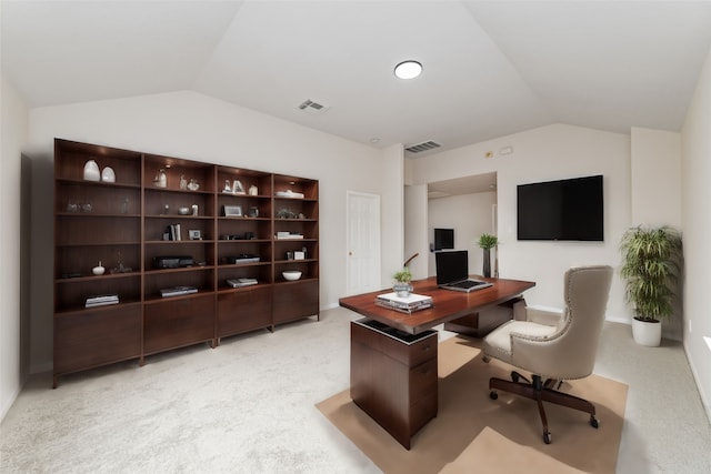 office area featuring lofted ceiling, visible vents, and light carpet