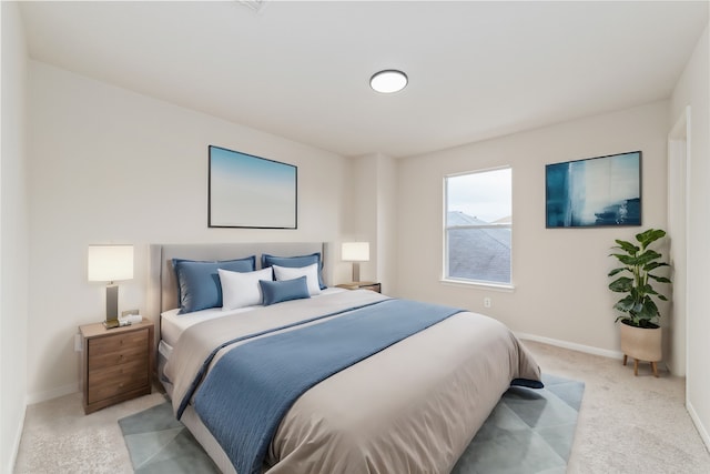 bedroom with baseboards and light colored carpet