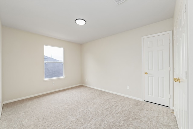 unfurnished room with carpet flooring and baseboards