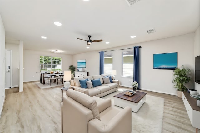 living area with light wood-style flooring, visible vents, a wealth of natural light, and recessed lighting