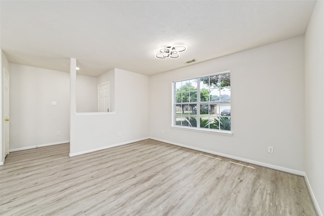 unfurnished room with visible vents, baseboards, and wood finished floors