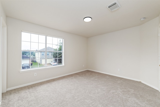 unfurnished room featuring carpet floors, baseboards, and visible vents