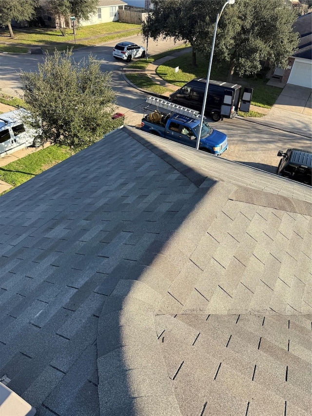 exterior details featuring roof with shingles