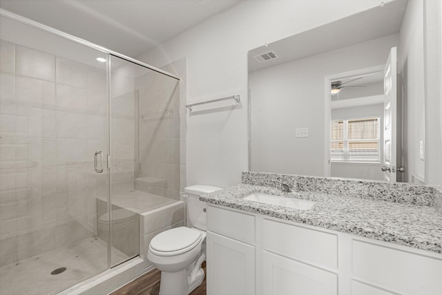 bathroom with vanity, ceiling fan, toilet, and walk in shower