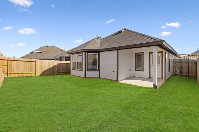 rear view of property featuring a lawn and a patio