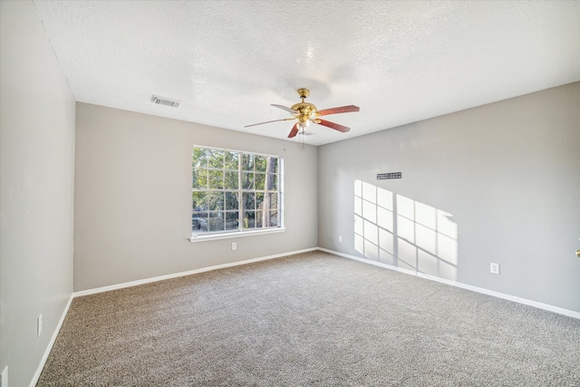 spare room with ceiling fan, carpet, and a textured ceiling