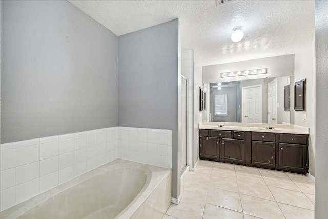 bathroom with tile patterned flooring, vanity, a textured ceiling, and plus walk in shower