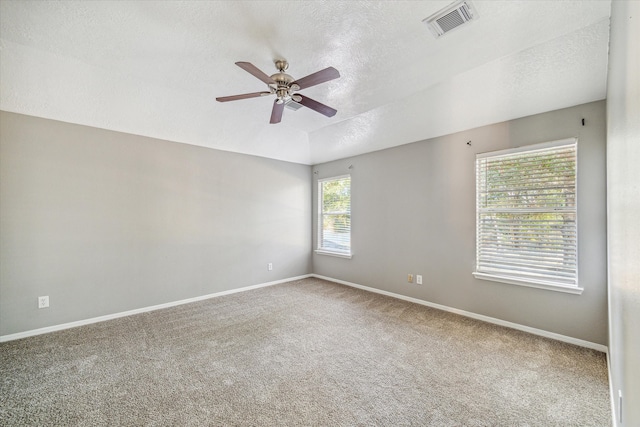 carpeted spare room with a textured ceiling and ceiling fan