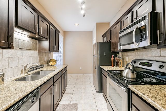 kitchen featuring light stone counters, light tile patterned floors, sink, and appliances with stainless steel finishes