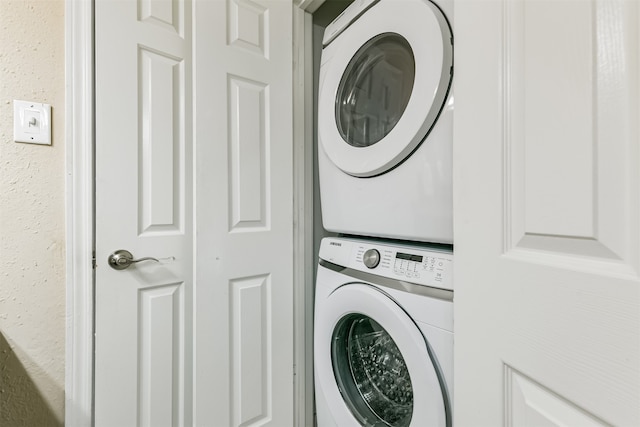 washroom with stacked washing maching and dryer