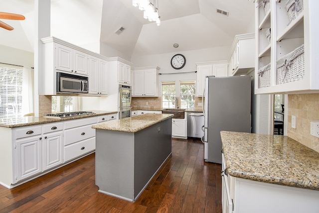 kitchen featuring white cabinets, a kitchen island, dark wood-type flooring, and appliances with stainless steel finishes