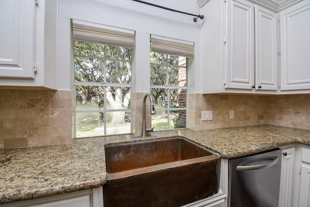 kitchen with white cabinets, decorative backsplash, light stone counters, and sink